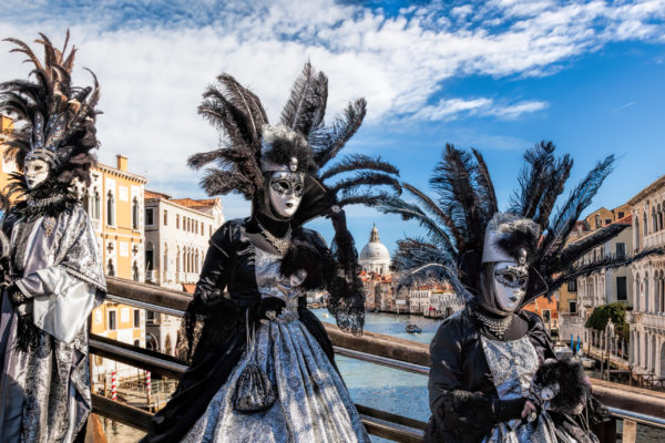 Famous,Carnival,Masks,On,Bridge,Against,Grand,Canal,In,Venice,